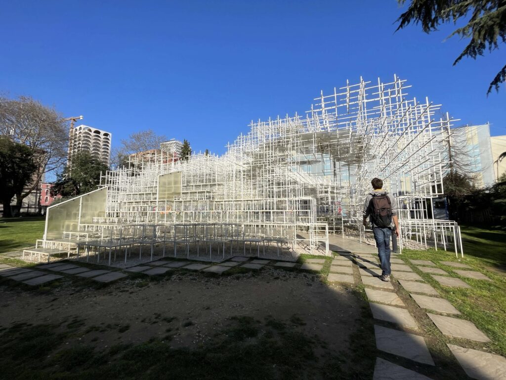 Mann betritt Kunstinstallation aus Stäben