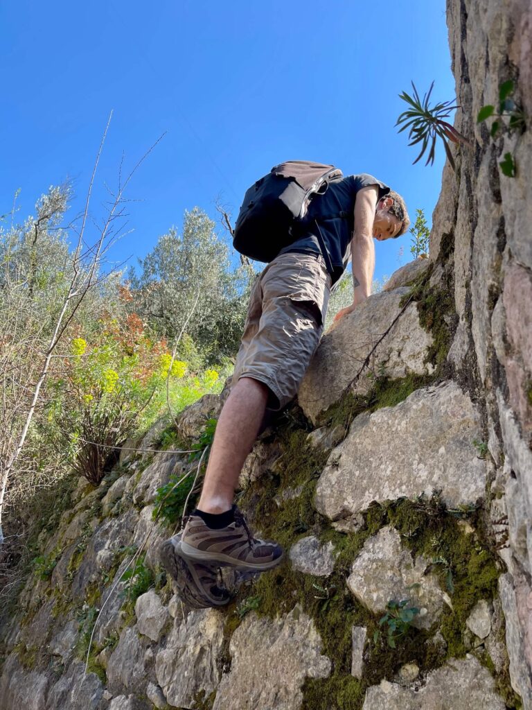Mann klettert Mauer hoch