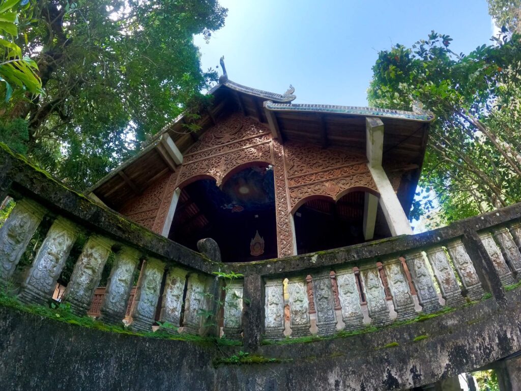 Holztempel in Thailand mit steinerner Balustrade
